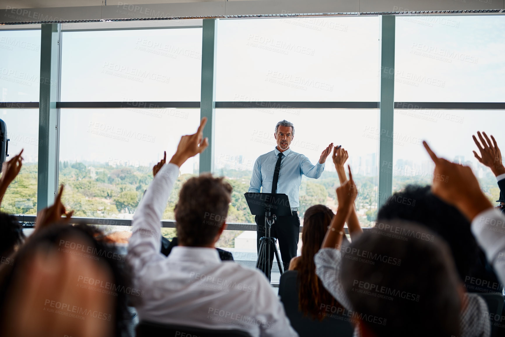 Buy stock photo Cropped shot of a group of young businesspeople sitting with their hands raised during a seminar in the conference room