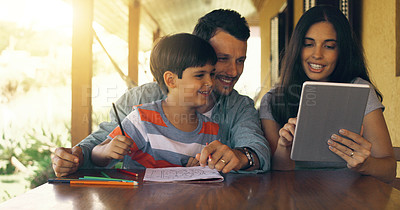 Buy stock photo Cropped shot of a young family colouring in and using a tablet by the table outside