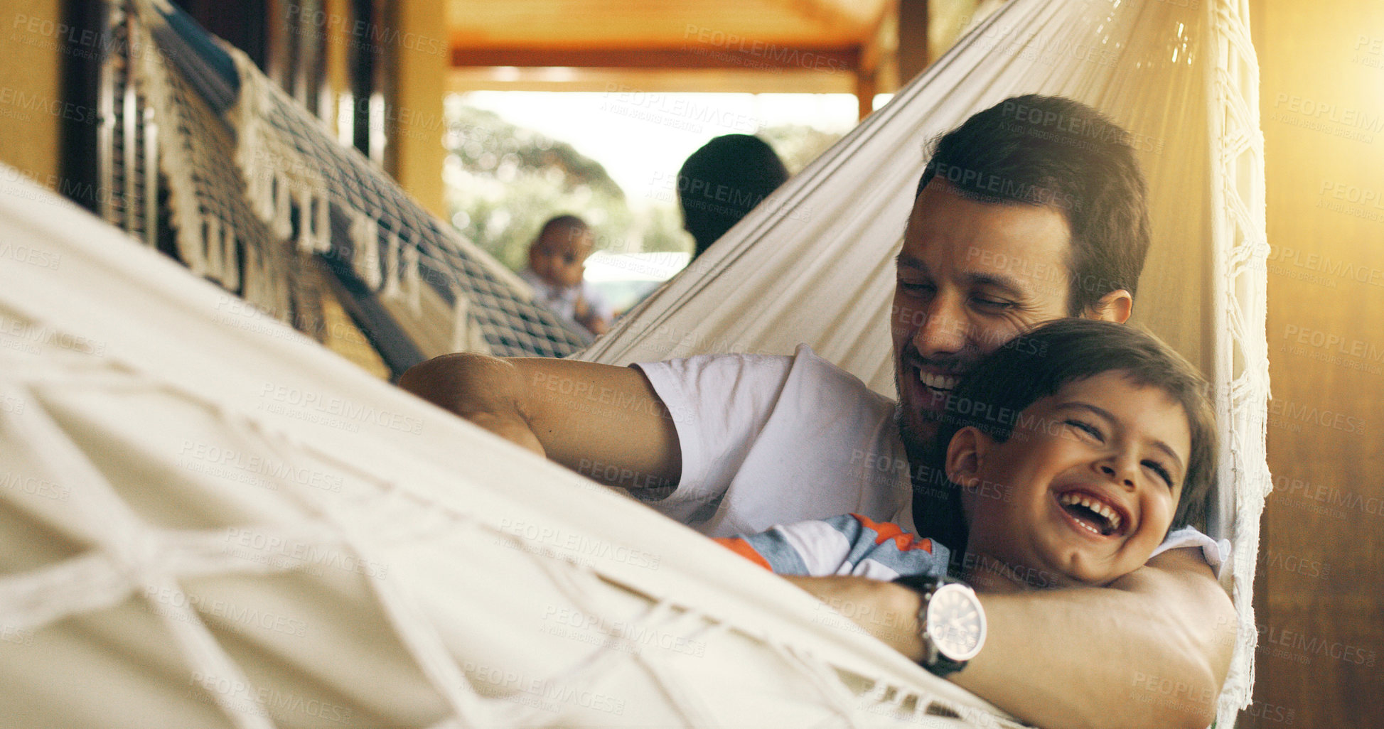 Buy stock photo Cropped shot of a father tickling his adorable son on a hammock outside