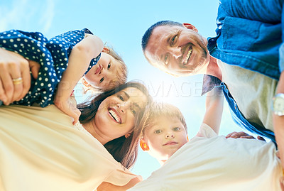 Buy stock photo Low angle shot of a happy family bonding together outdoors