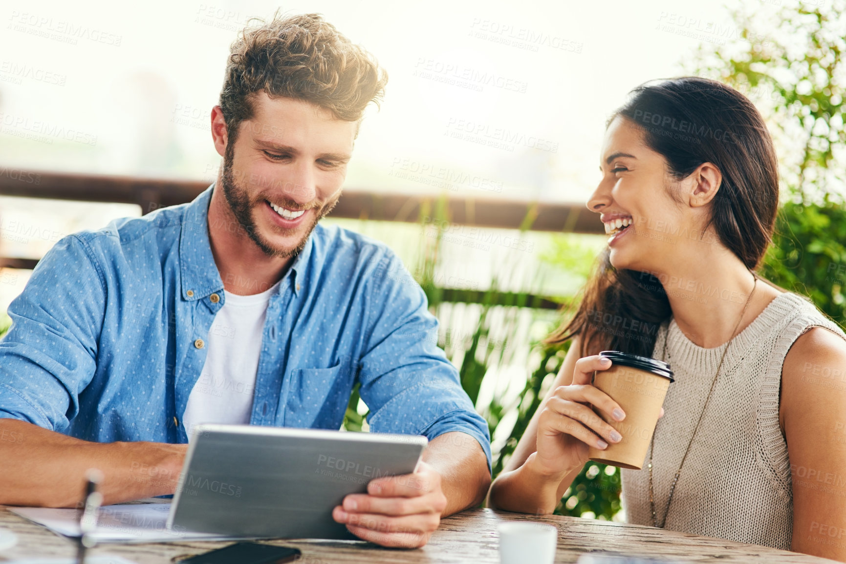 Buy stock photo Shot of two businesspeople using a digital tablet together outdoors