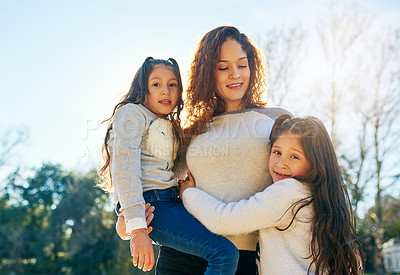 Buy stock photo Cropped shot of a beautiful young mother and her adorable daughters outdoors