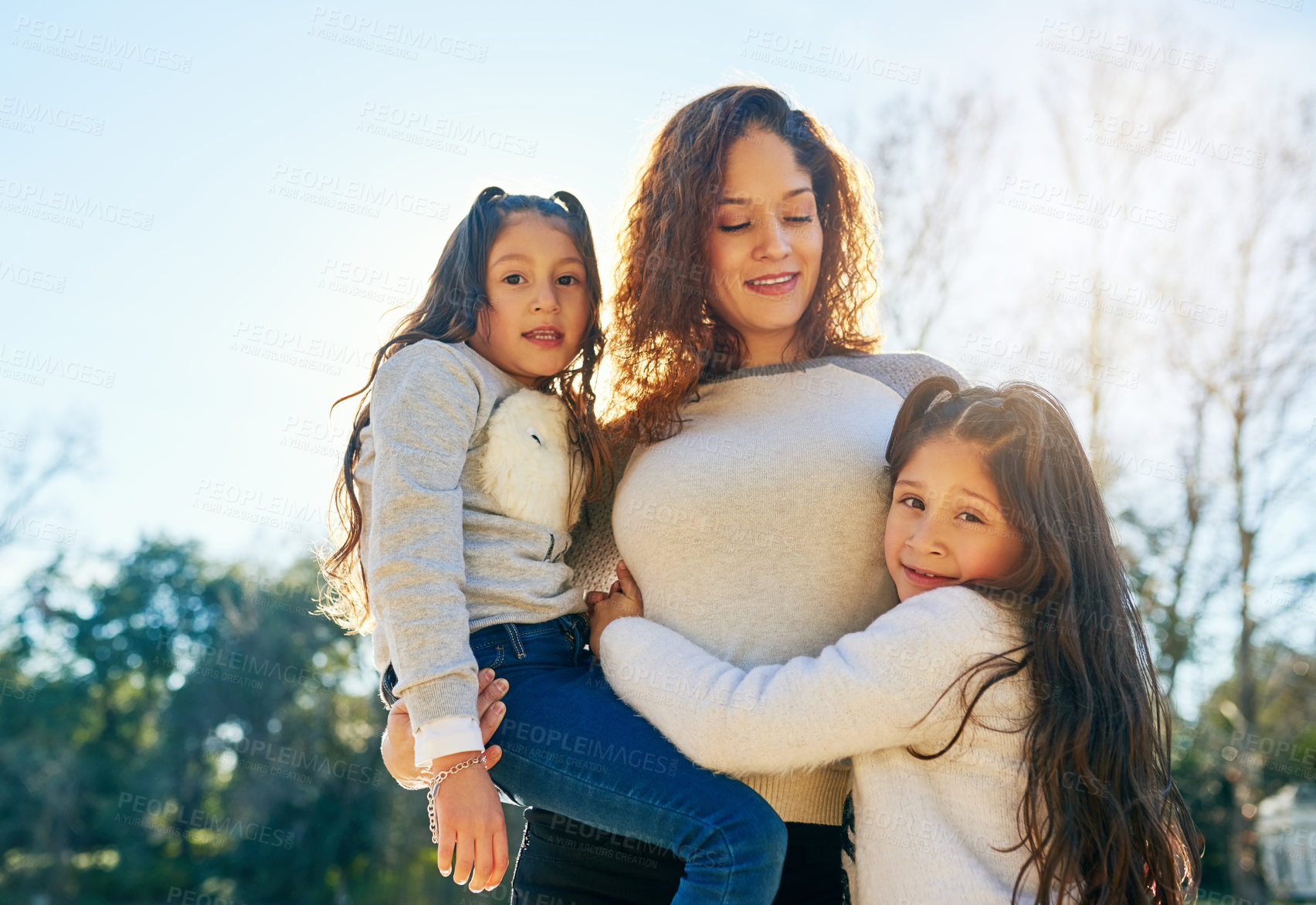 Buy stock photo Cropped shot of a beautiful young mother and her adorable daughters outdoors