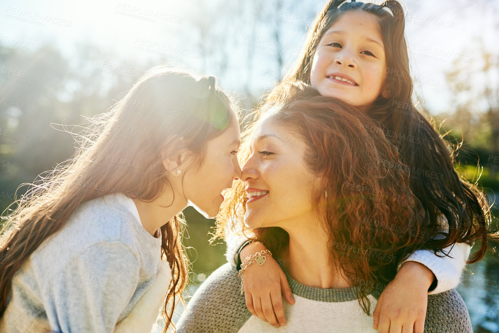 Buy stock photo Cropped shot of a beautiful young mother and her adorable daughters outdoors