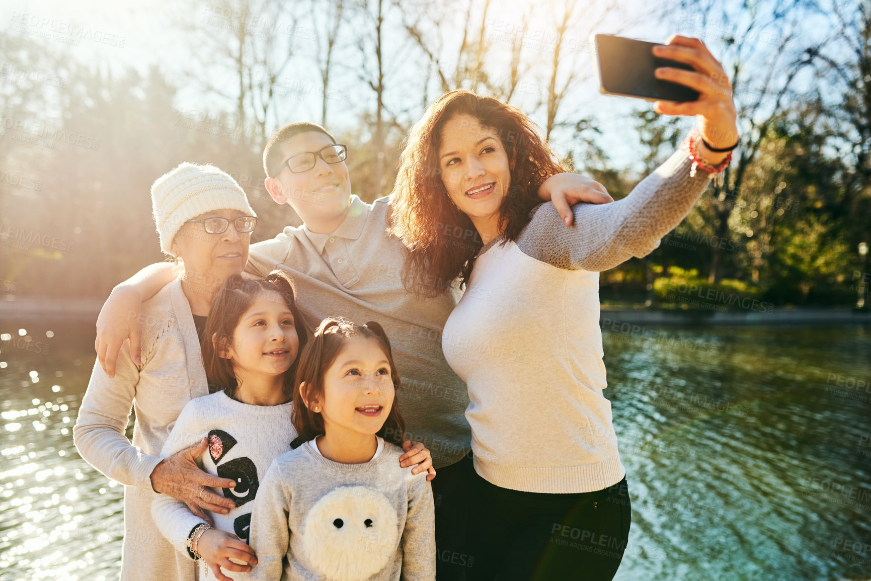 Buy stock photo Selfie, family and smile of group, outdoor and bonding with children, lake and photography with grandma. River, man and woman with grandparent, kids and profile picture of people, travel and holiday