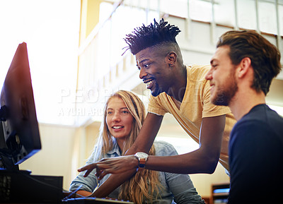 Buy stock photo Shot of a group of university students working together on a computer in the library at campus