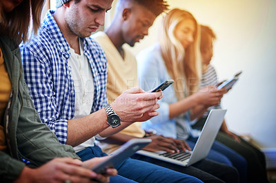 Buy stock photo Shot of a group of university students using their digital devices at campus