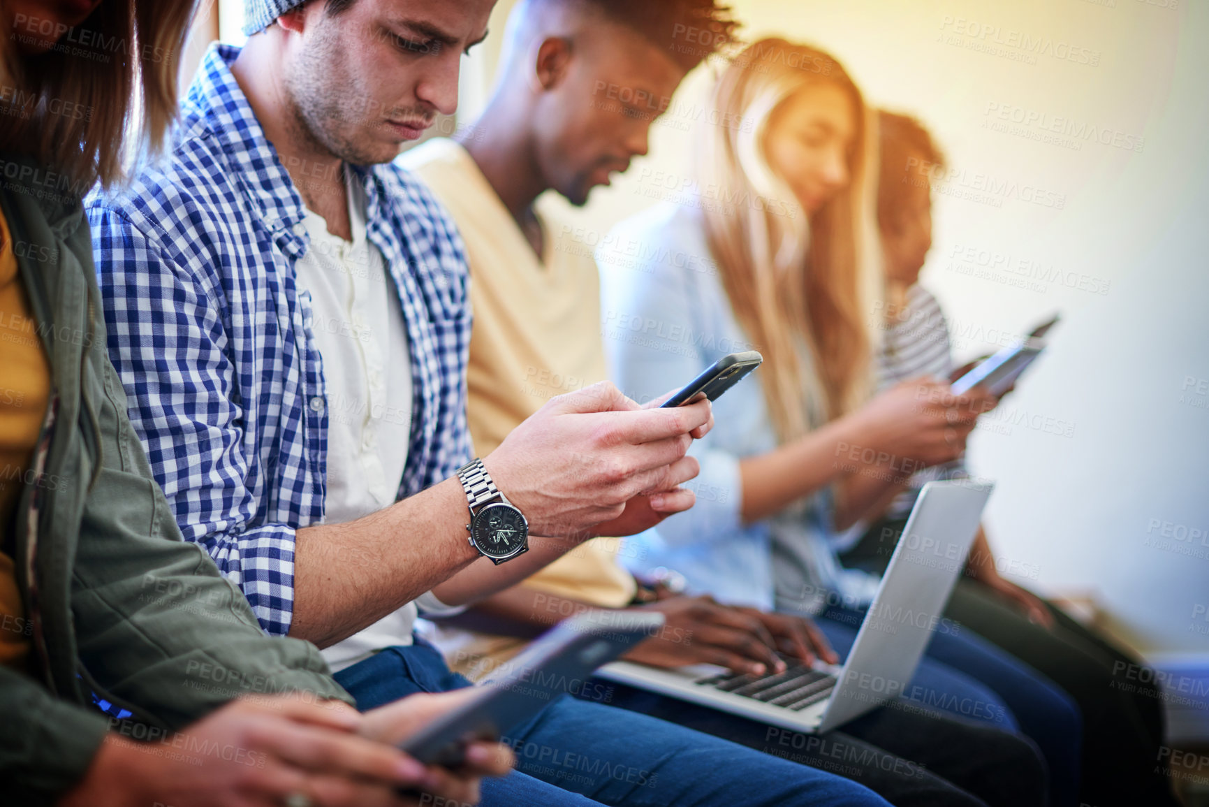 Buy stock photo Shot of a group of university students using their digital devices at campus