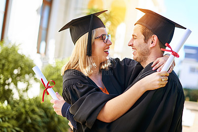 Buy stock photo Shot of a young couple embracing each other on graduation day