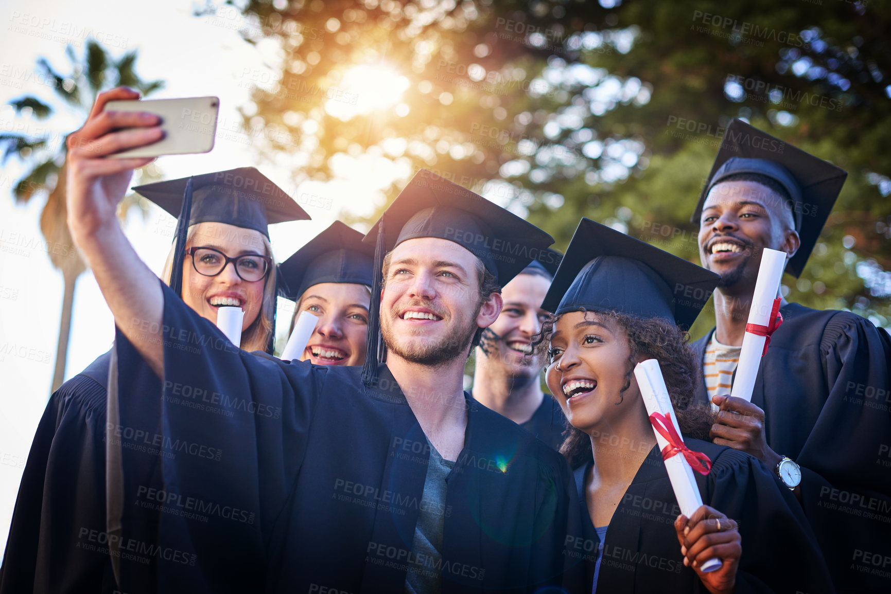 Buy stock photo Cropped shot of a group of university students taking a selfie on graduation day