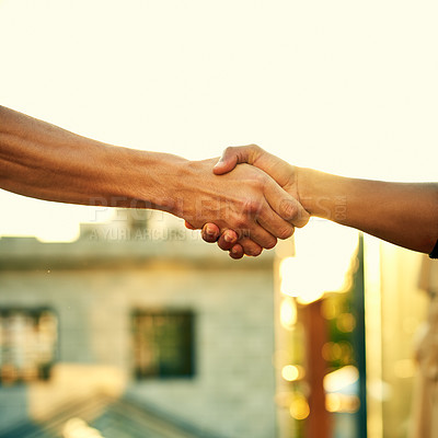 Buy stock photo Cropped shot of two men shaking hands outdoors