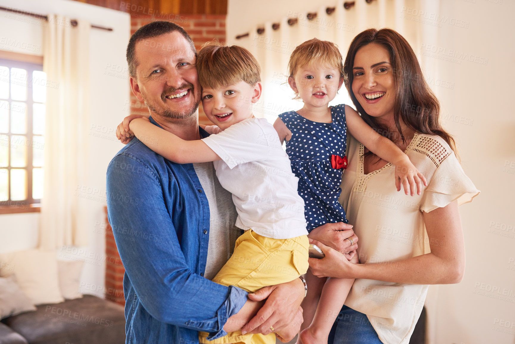 Buy stock photo Portrait, happy family and parents carrying kids in home for bonding, love and support. Face, mother and father hug children in living room for connection, development and funny people laugh in USA