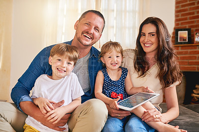 Buy stock photo Portrait of a happy young family of four relaxing together on the sofa at home