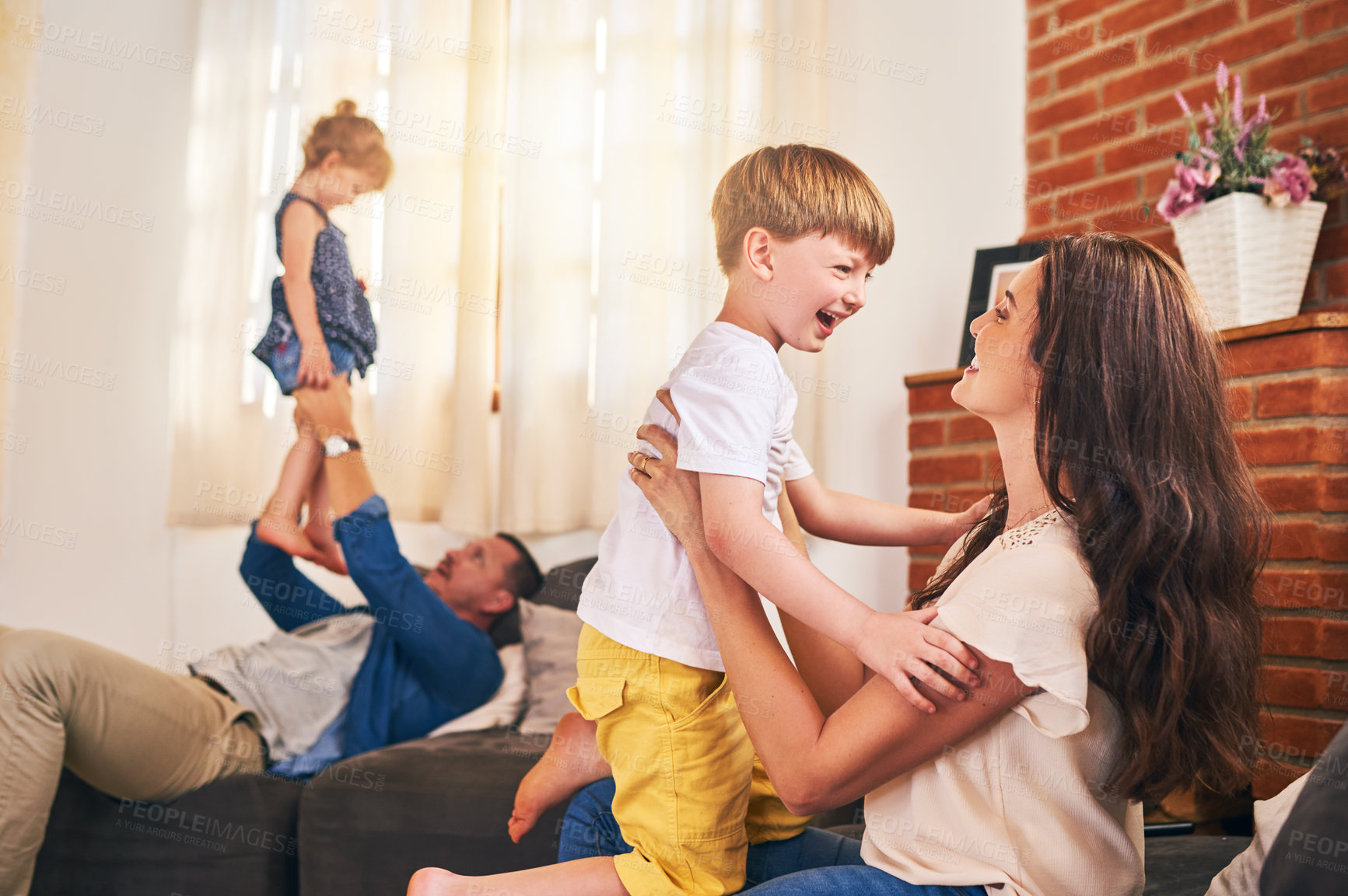 Buy stock photo Shot of a happy young family enjoying playtime together at home