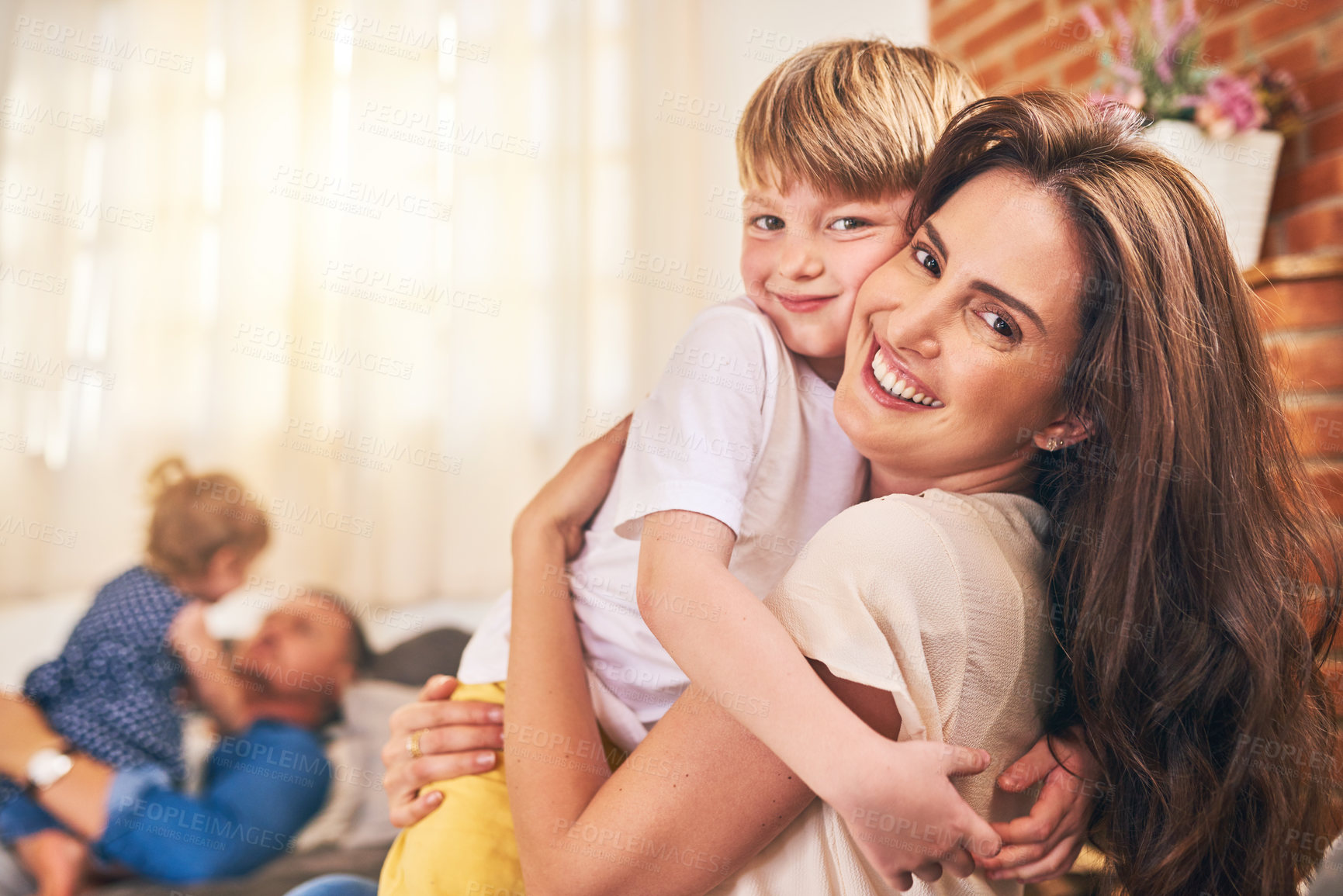 Buy stock photo Portrait of a happy little boy hugging his mother during family playtime at home