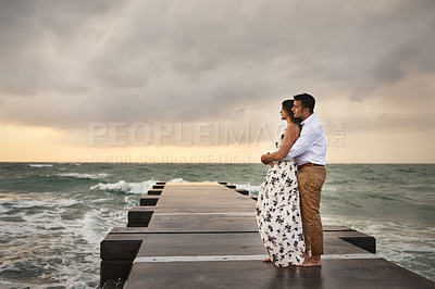 Buy stock photo Full length shot of an affectionate young couple taking in the beach views while standing on a jetty