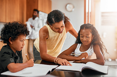 Buy stock photo Shot of a mom helping her children with their homework