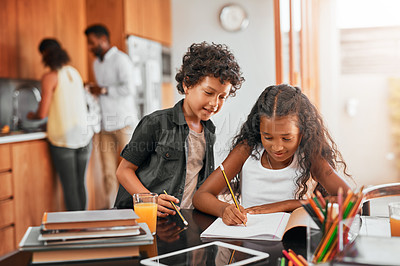 Buy stock photo Shot of a boy helping his sister with her homework