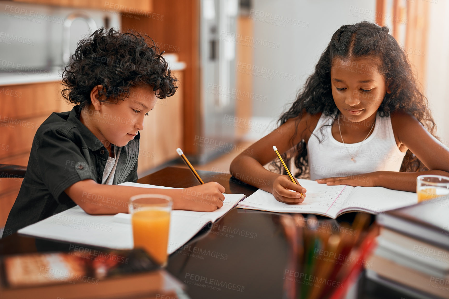 Buy stock photo Shot of a sister and brother doing their homework together