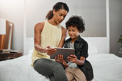 Buy stock photo Shot of a mother and son using a digital tablet together at home