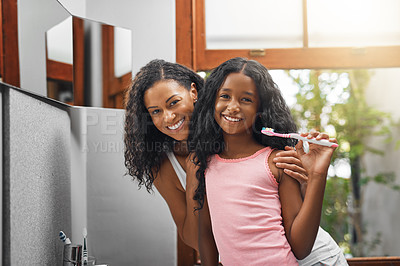 Buy stock photo Cropped portrait of an attractive young woman and her daughter brushing their teeth in the bathroom at home