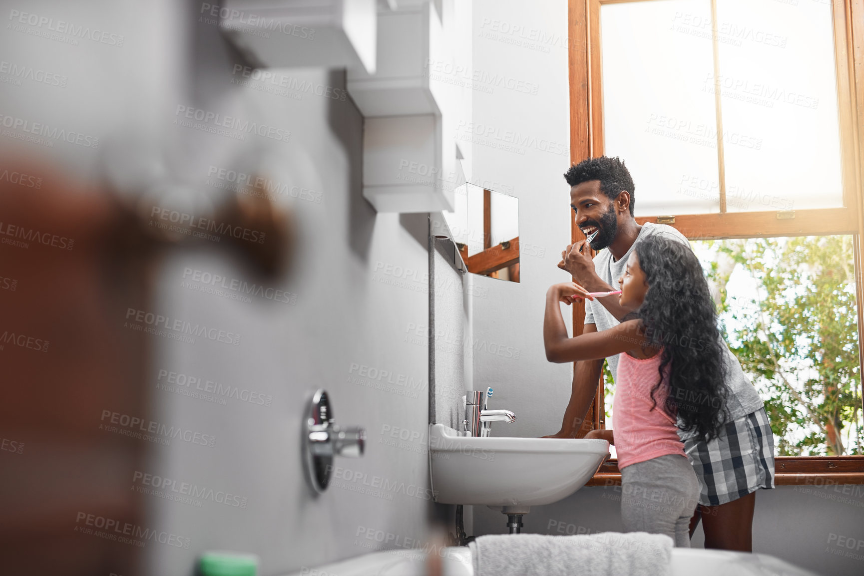 Buy stock photo Cropped shot of a handsome young man and his daughter brushing their teeth in the bathroom at home