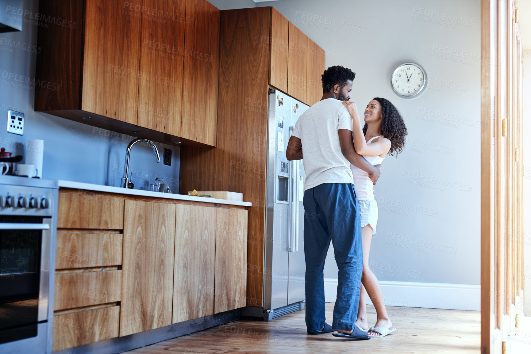 Buy stock photo Full length shot of an affectionate young couple dancing in their kitchen at home