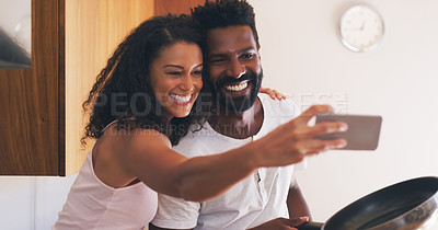 Buy stock photo Cropped shot of a young attractive couple taking a selfie in the kitchen at home