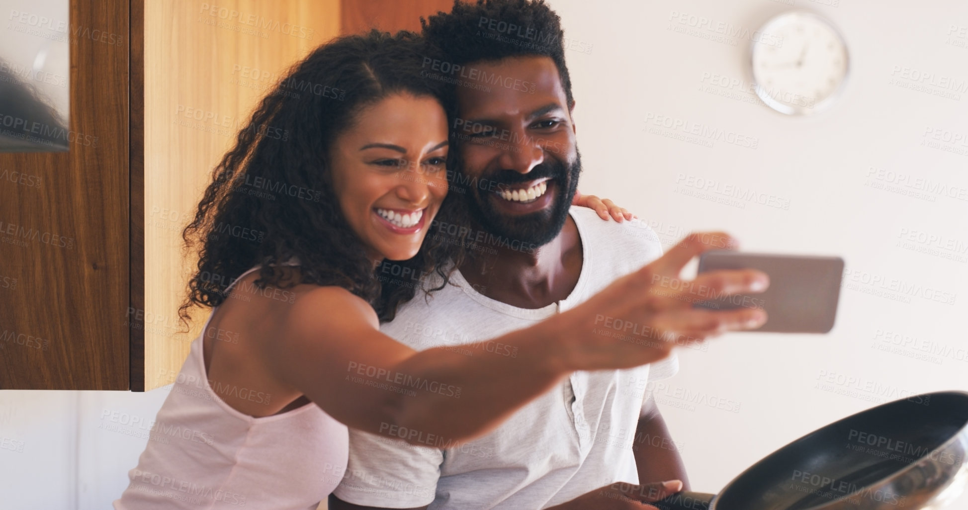 Buy stock photo Cropped shot of a young attractive couple taking a selfie in the kitchen at home