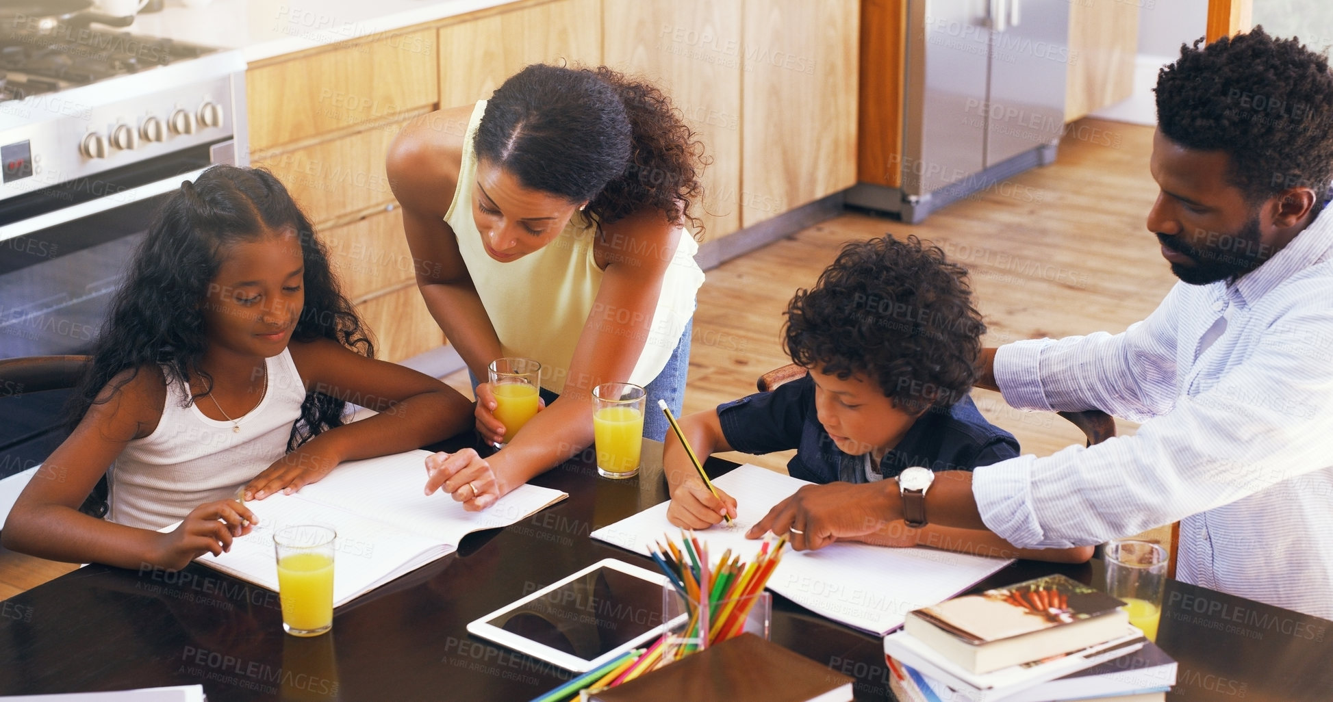 Buy stock photo Cropped shot of parents helping their two children with their schoolwork at home