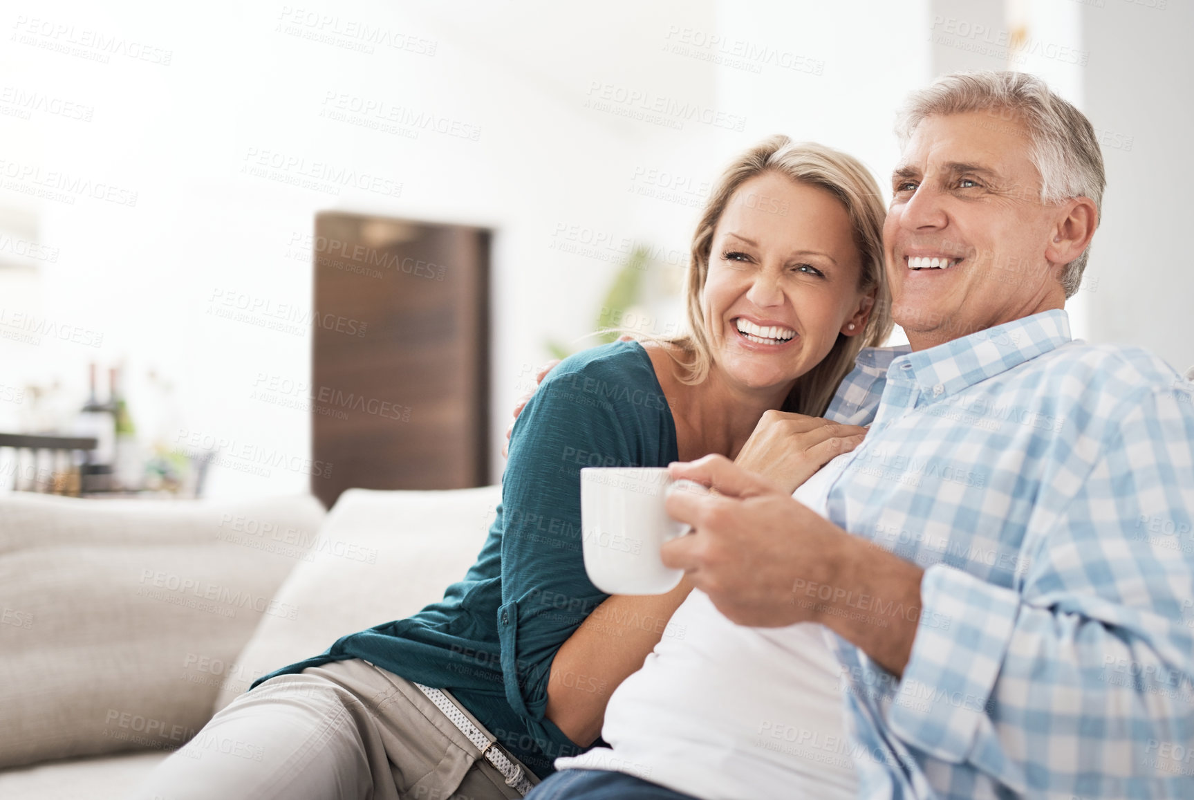 Buy stock photo Cropped shot of an affectionate mature couple relaxing together on the sofa at home