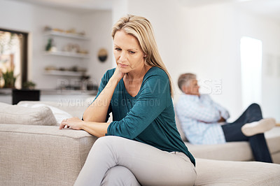 Buy stock photo Cropped shot of a mature woman looking despondent after having a fight with her husband at home