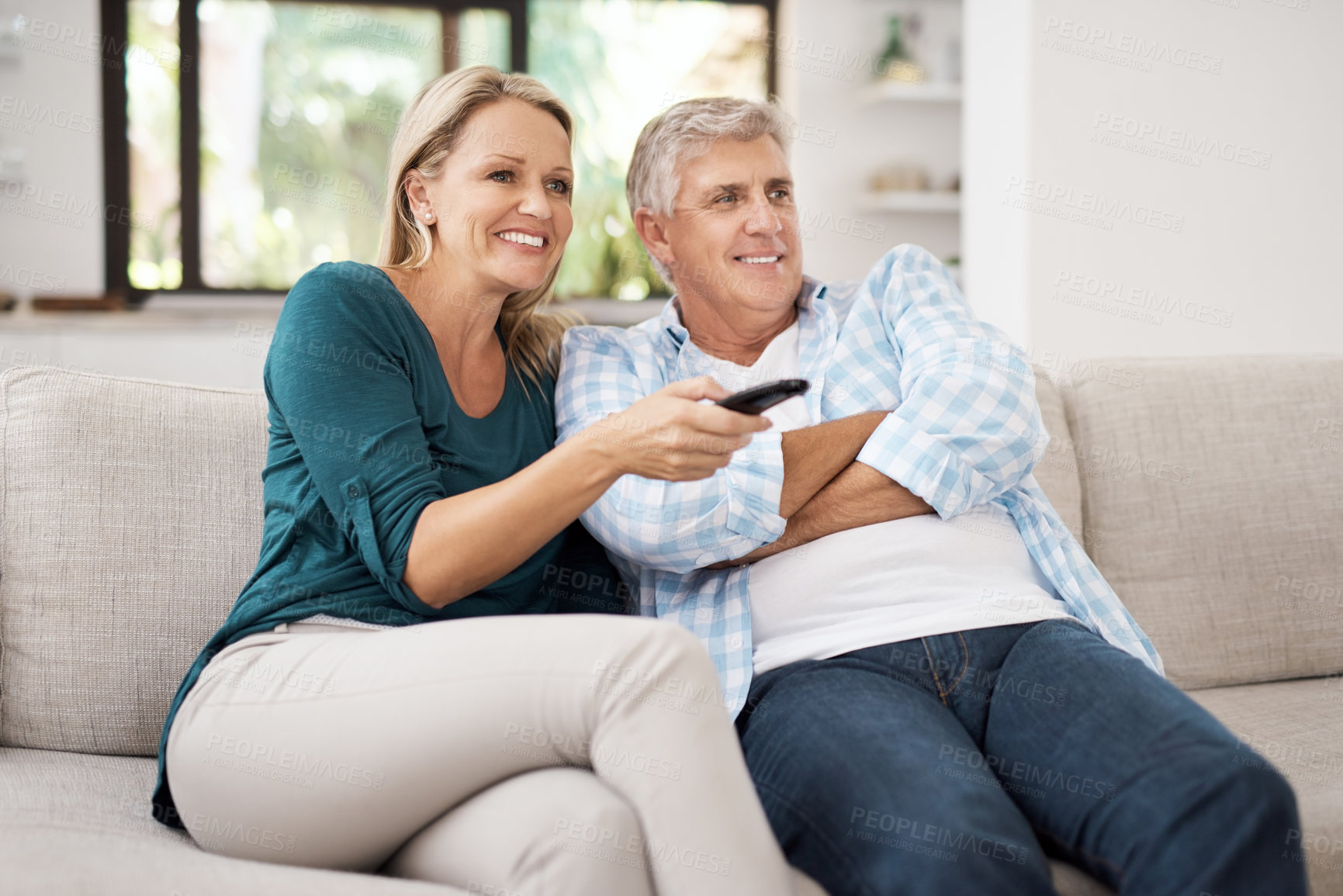 Buy stock photo Cropped shot of an affectionate mature couple watching television together at home