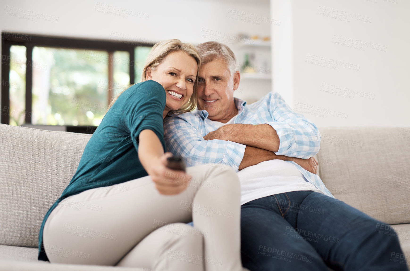 Buy stock photo Cropped portrait of an affectionate mature couple watching television together at home