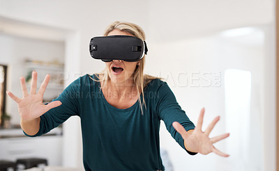 Buy stock photo Cropped shot of a mature woman using a VR headset at home