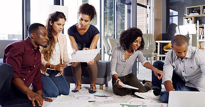 Buy stock photo Cropped shot of a group of diverse businesspeople working together on the floor in an modern office