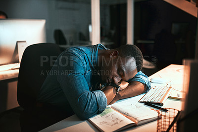 Buy stock photo High angle shot of a young male designer sleeping at his desk while working late in the office