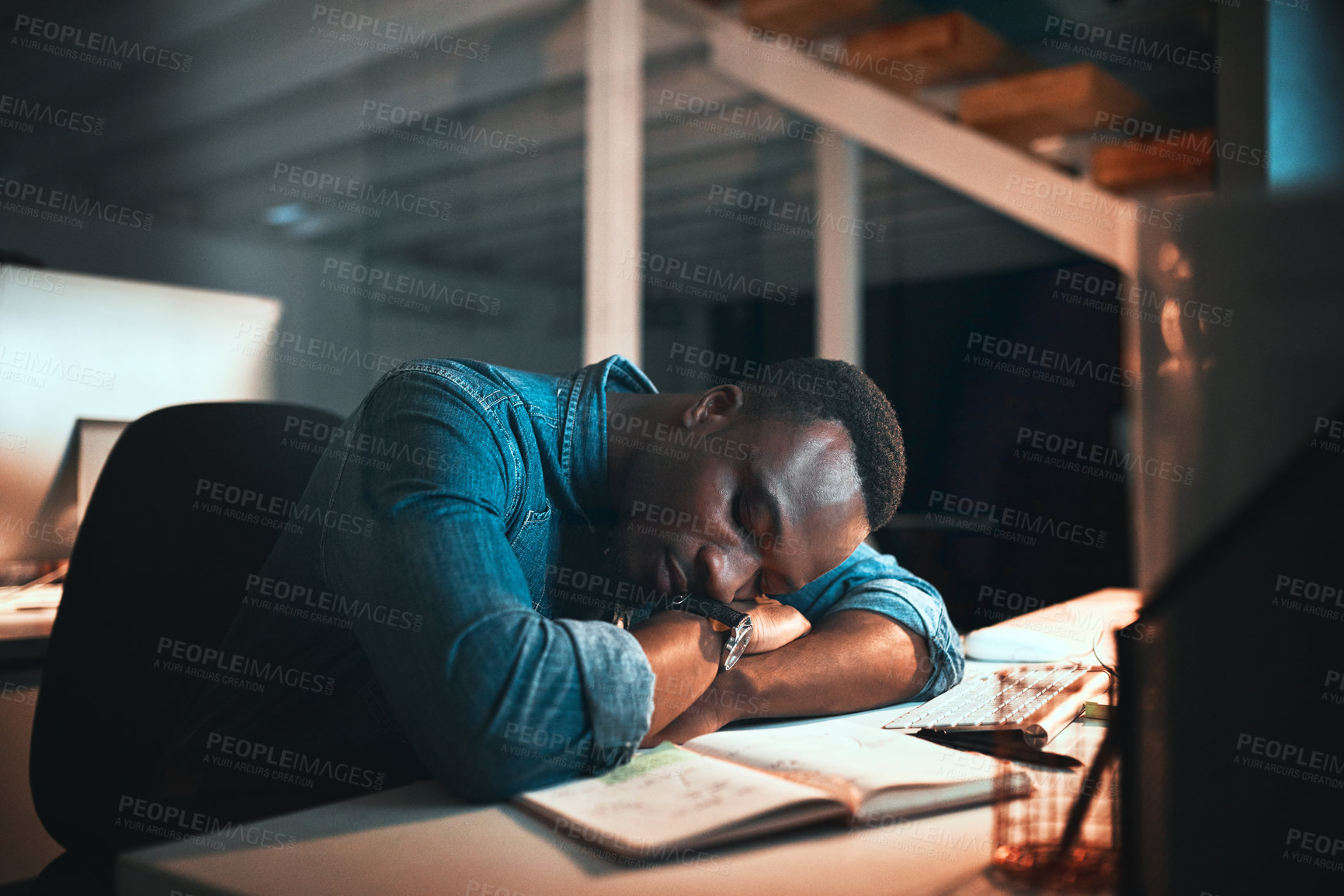 Buy stock photo Cropped shot of a young male designer sleeping at his desk while working late in the office