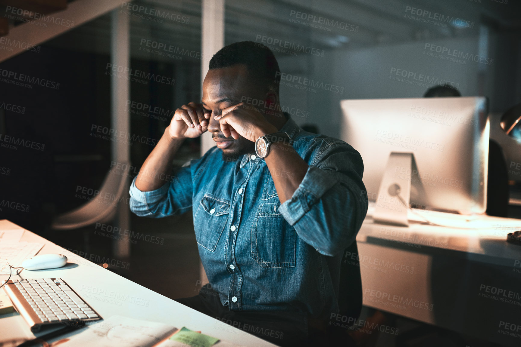Buy stock photo Cropped shot of a young male designer looking stressed while working on his computer in the office