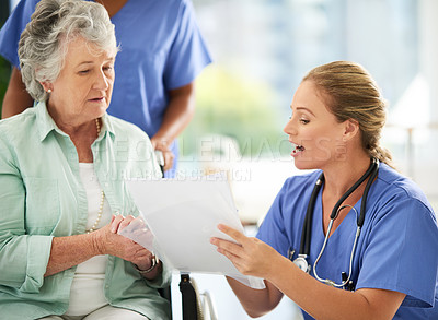 Buy stock photo Cropped shot of an attractive female nurse discussing treatments with her wheelchair-bound senior patient in the hospital