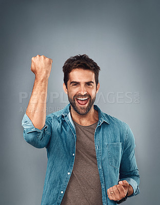 Buy stock photo Happy man, fist and celebration for winning, success or victory against a grey studio background. Excited portrait of male person or winner in achievement, win or accomplishment on mockup space