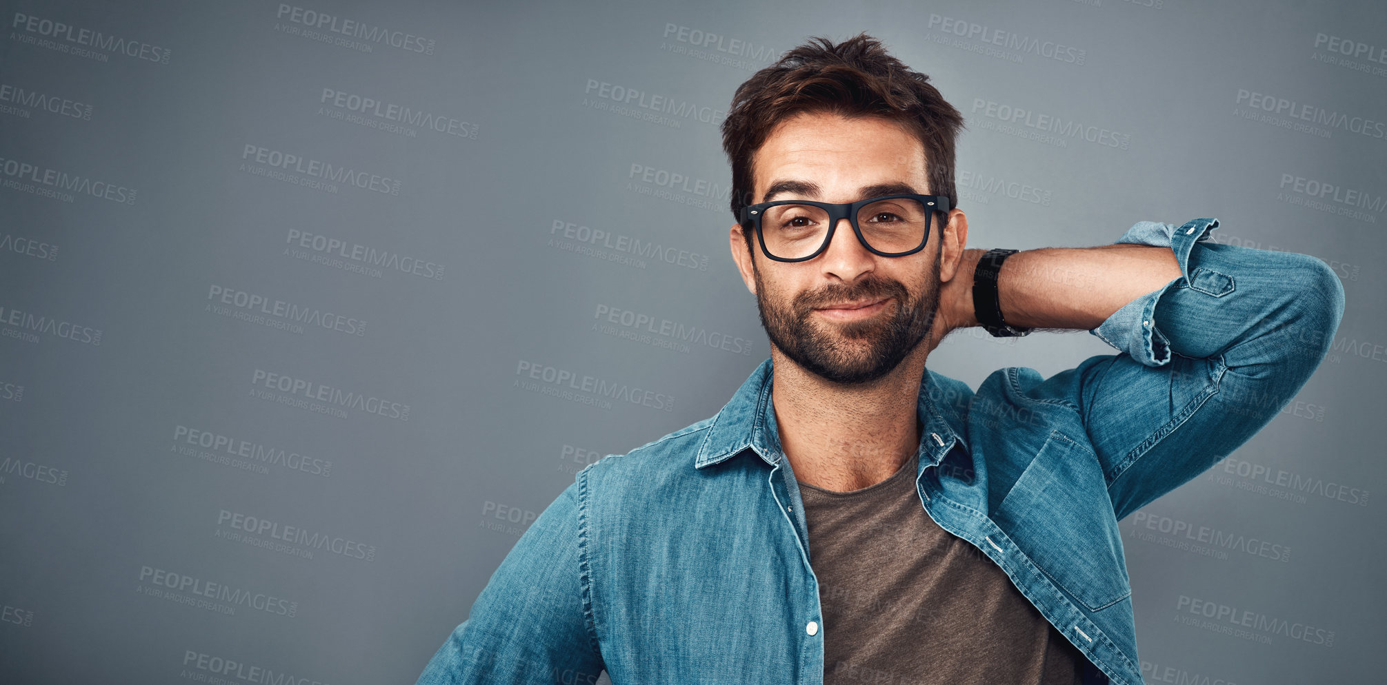 Buy stock photo Studio shot of a handsome young man posing against a grey background