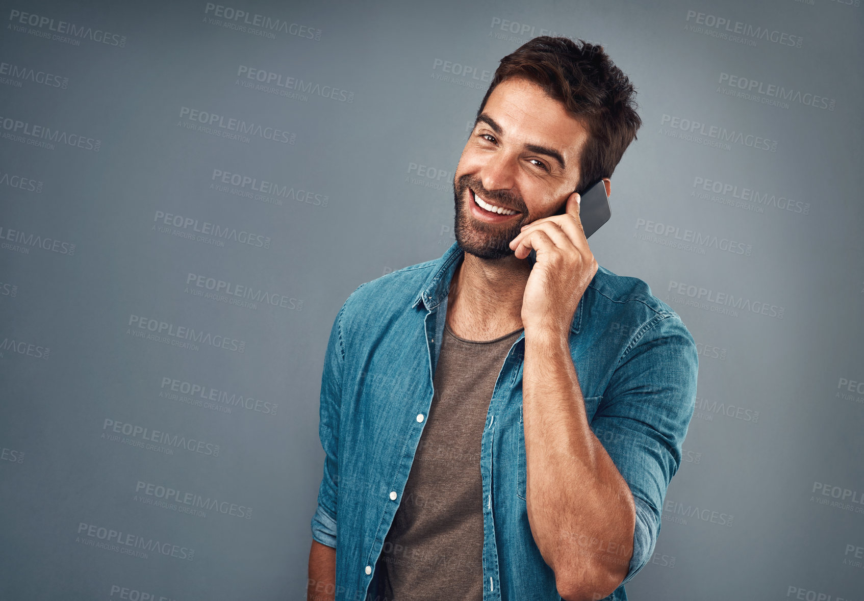 Buy stock photo Portrait, man and fashion with phone call in studio backdrop for style, cheerful on mobile in gray background. Male person, smile and outfit for confidence, retail or sale in communication for promo