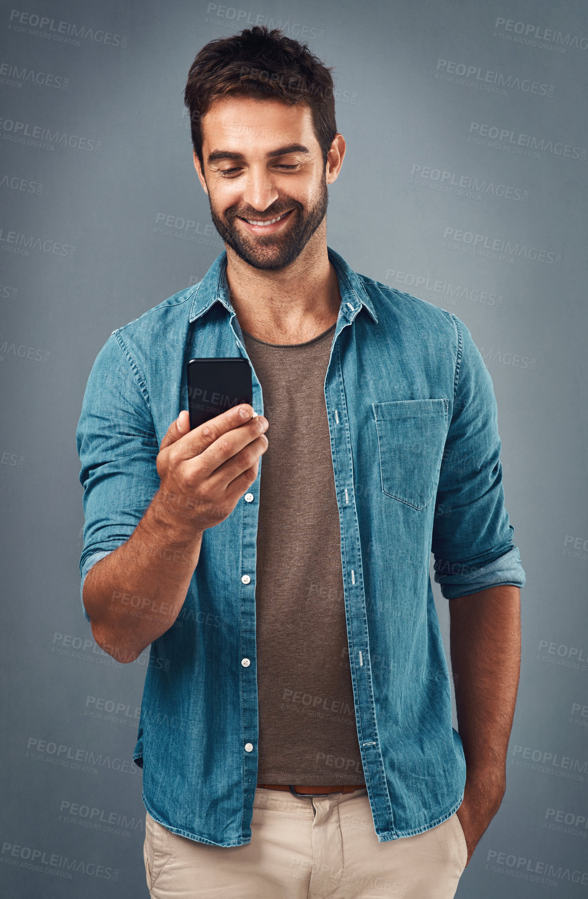 Buy stock photo Cellphone, smile and read with man in studio, communication and social media on gray background. Internet, online and scroll for texting on dating app, talk or happy male person on mobile for love