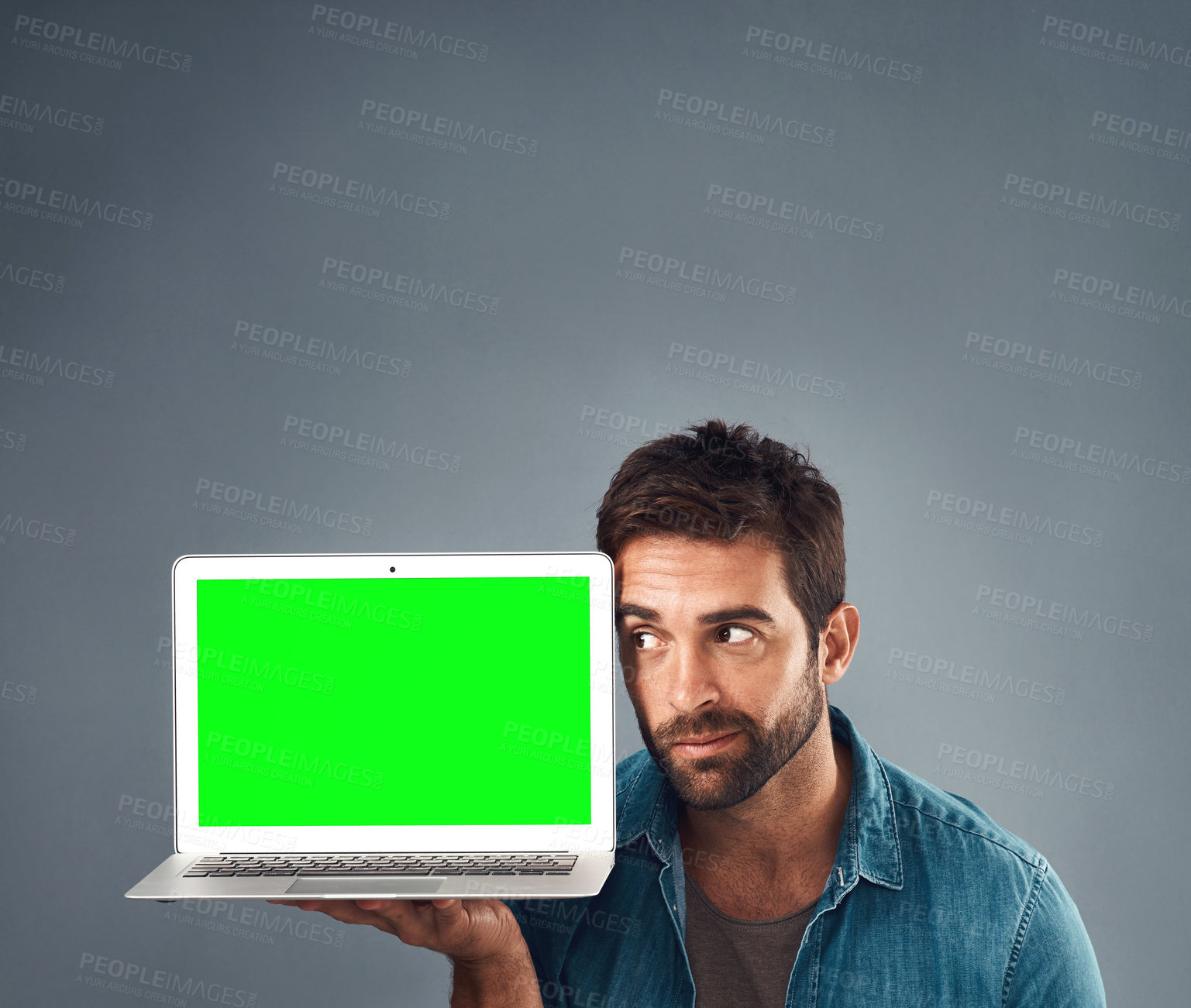 Buy stock photo Man, laptop and thinking on mockup green screen for advertising or marketing against a grey studio background. Thoughtful male person showing computer display, mock up or copy space for advertisement