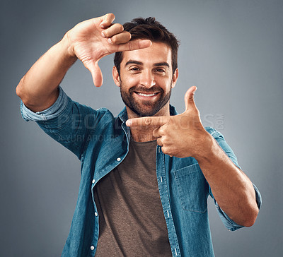 Buy stock photo Frame, face and portrait of man in studio on gray background with happiness, confident and smile. Finger border, fashion and happy male person with hand sign for picture, photography and perspective