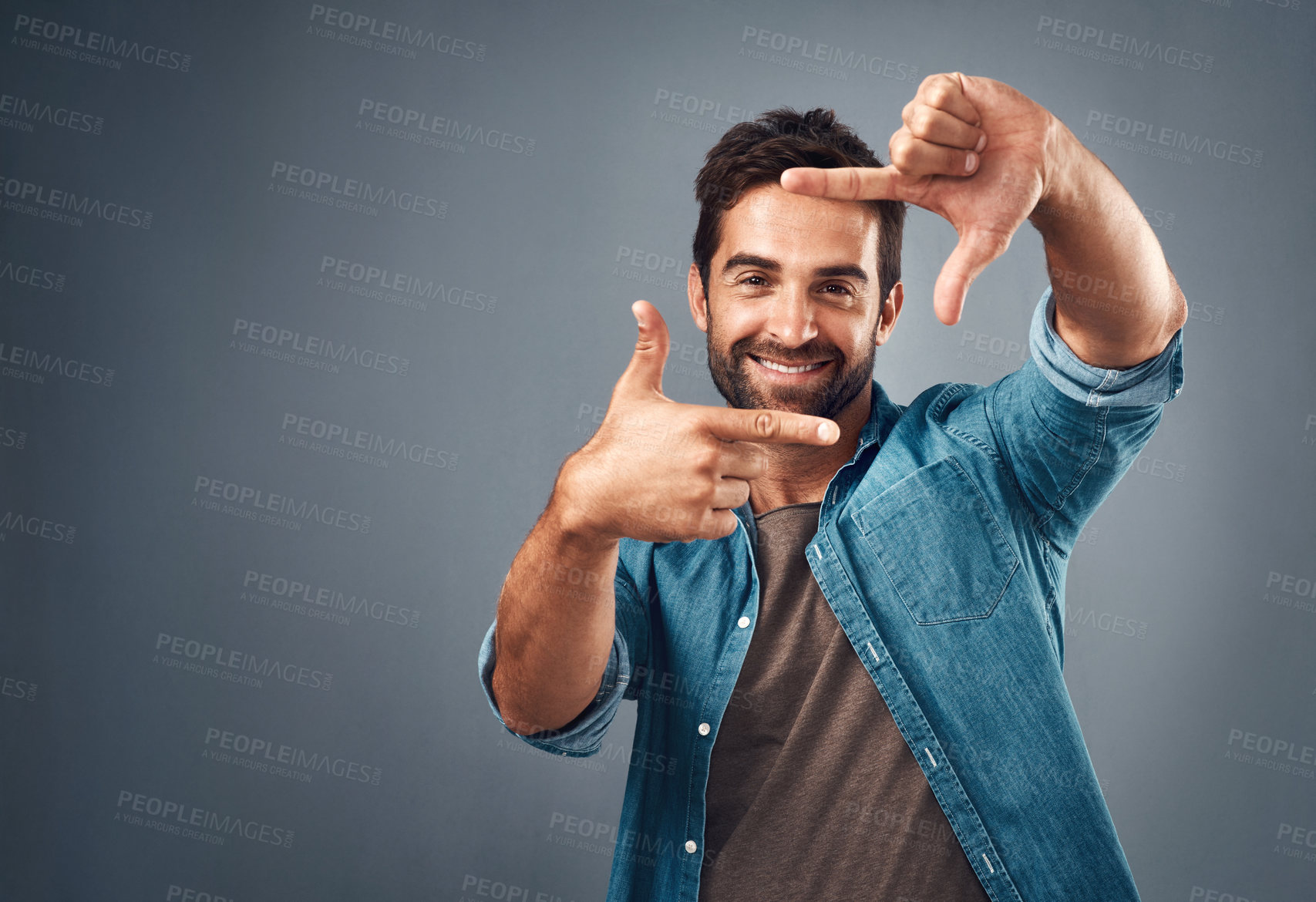 Buy stock photo Frame, hands and portrait of man in studio on gray background with happiness, confident and smile. Finger border, mockup and male person face with hand sign for picture, photography and perspective
