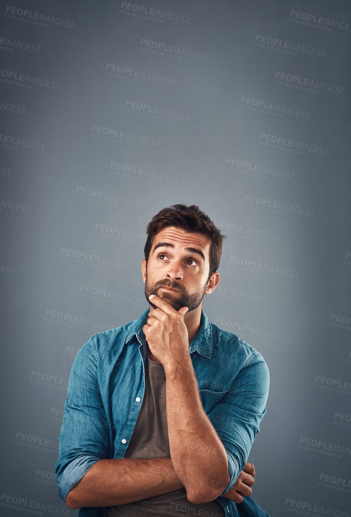 Buy stock photo Studio shot of a handsome young man looking thoughtful against a grey background