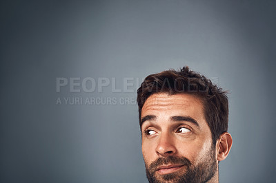 Buy stock photo Studio shot of a handsome young man looking thoughtful against a grey background