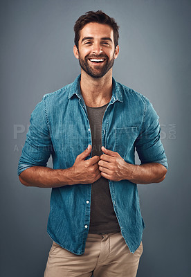 Buy stock photo Studio shot of a handsome and happy young man posing against a grey background